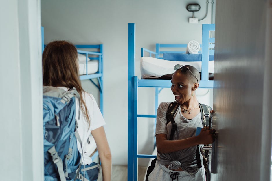 hostel dormitory room with multiple beds and backpack