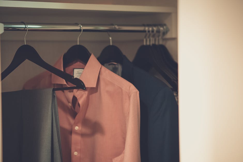 man arranging clothes in closet