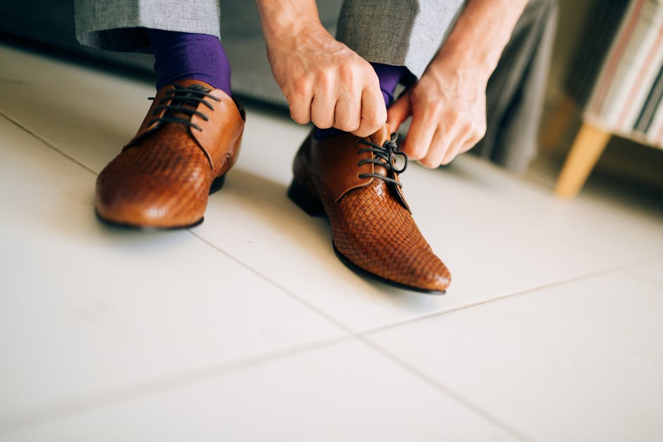 man tying laces on elegant leather shoes