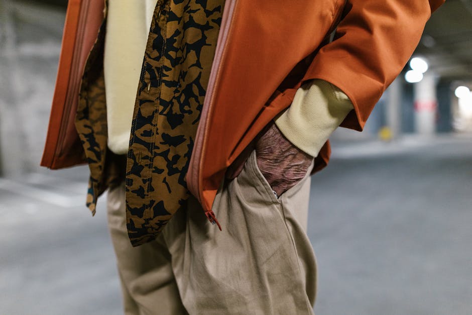 person layering clothes, neutral colors, outdoor city street