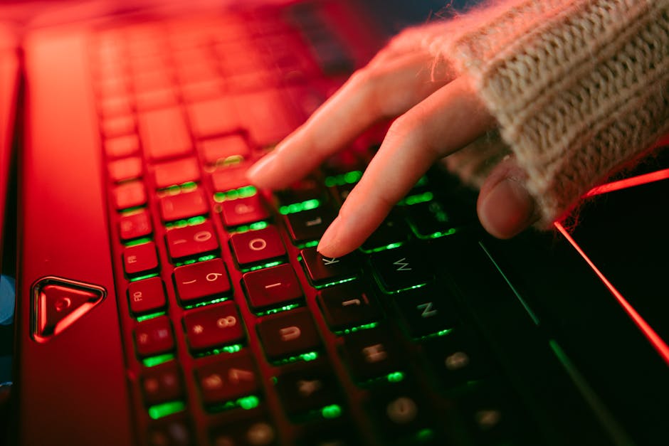 person typing on illuminated keyboard