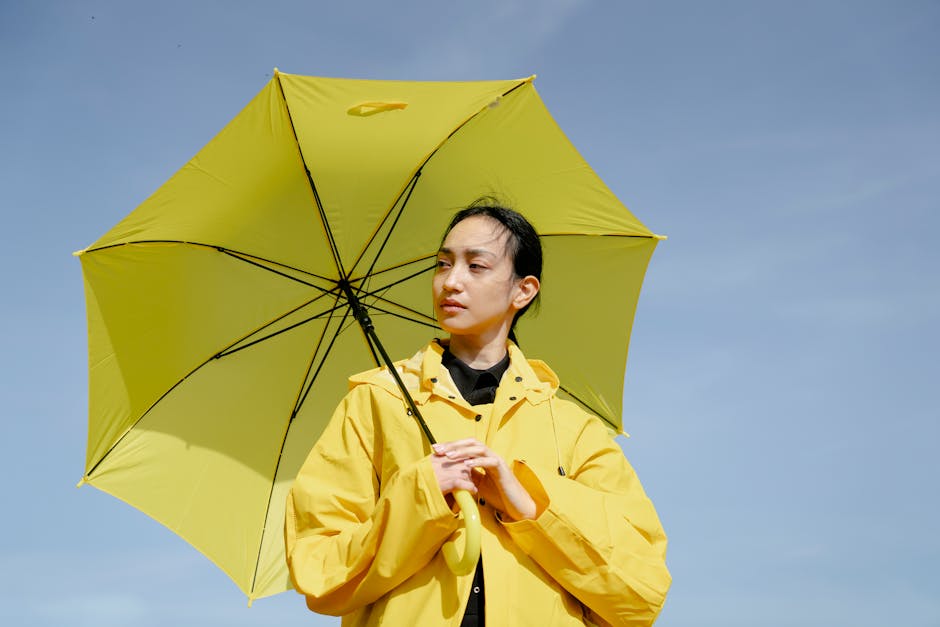 person wearing stylish raincoat with umbrella in São Paulo