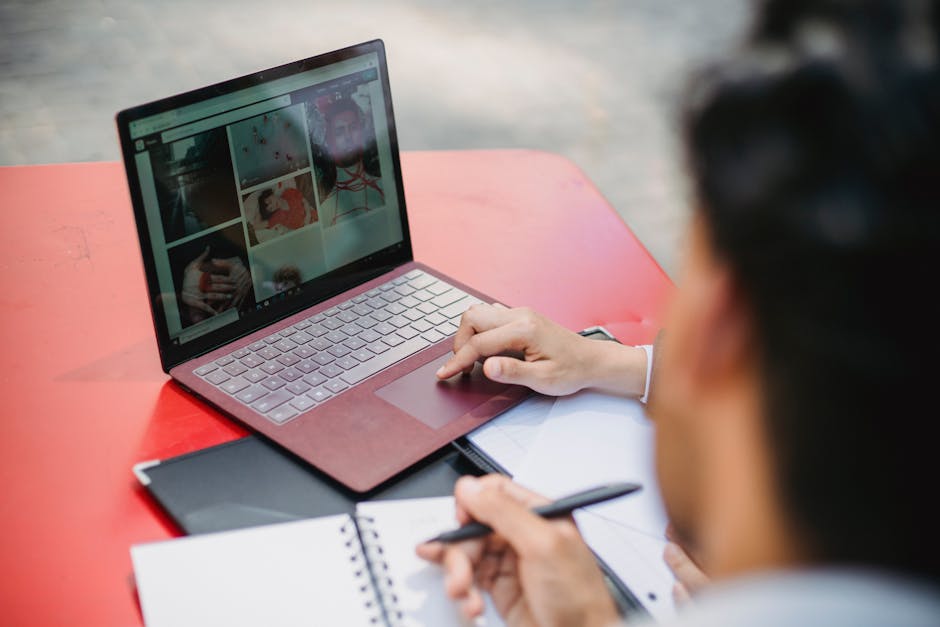person writing on laptop with creative images