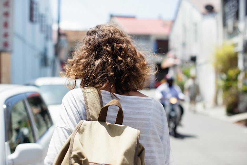 woman carrying backpack walking in city