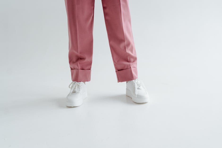 woman in wide leg pants and sneakers smiling