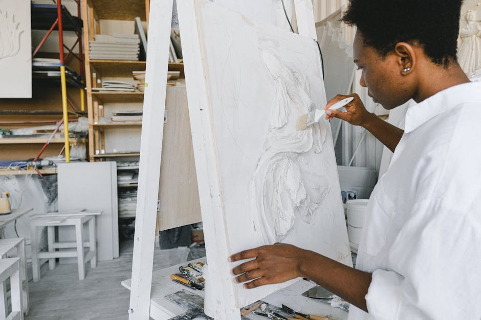 woman painting on canvas in studio