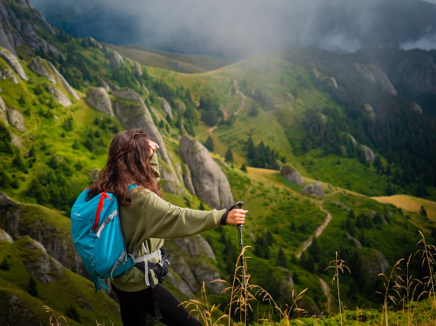 woman standing with backpack in mountains