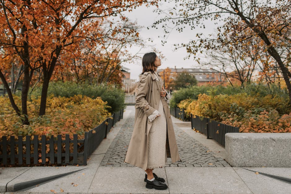 woman walking in park with trench coat