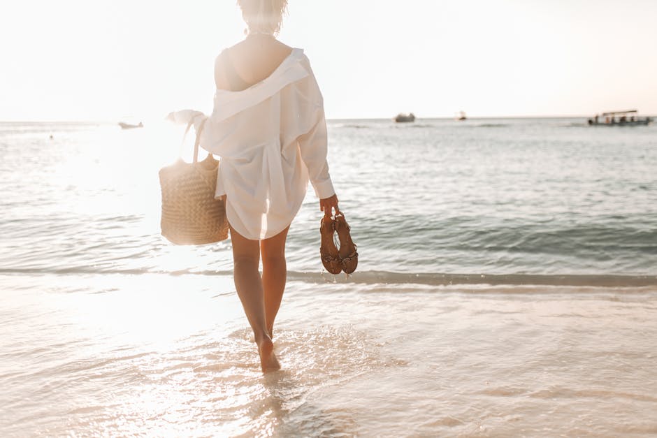 woman walking on beach in linen shirt